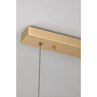 Detail of the Alvara pendant's linear brushed brass ceiling canopy and adjustable suspension cable