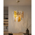 Amber and clear Murano glass chandelier illuminated above a modern dining table interior