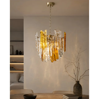 Amber and clear Murano glass chandelier illuminated above a modern dining table interior