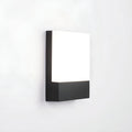 Angled side view of the modern LED wall light with a black aluminum base and frosted acrylic diffuser, mounted on a white wall