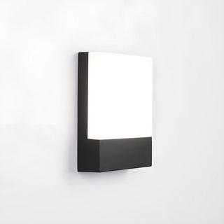 Angled side view of the modern LED wall light with a black aluminum base and frosted acrylic diffuser, mounted on a white wall