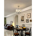 Aurem chrome glass chandelier styled above dining table in modern classic interior