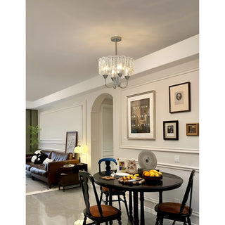 Aurem chrome glass chandelier styled above dining table in modern classic interior