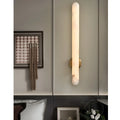 Modern alabaster wall sconce installed beside bed creating warm ambient light