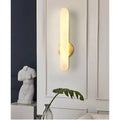 Aurora alabaster vertical wall sconce creating warm ambient lighting in modern luxury interior