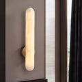 Luxury alabaster vertical wall sconce illuminating modern bedroom interior