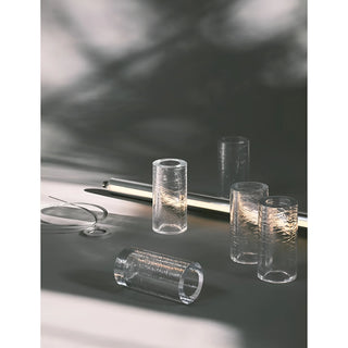 Close-up of modular glass light tube parts with textured surfaces laid out for assembly with metal fixture and cable