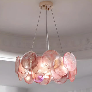 Blush pink round glass chandelier creating warm ambient lighting in contemporary interior
