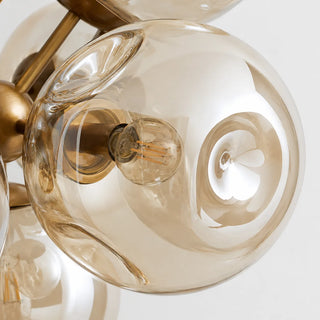 Close-up of an amber champagne-luster glass globe and E12 filament bulb on the Bollara chandelier