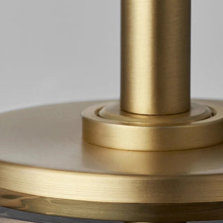 Close-up of brushed gold metal detail on modern amber glass pendant light fixture