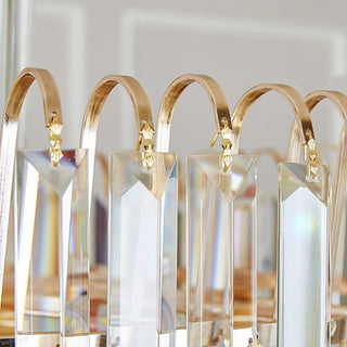 Close-up of Cap d'Ail chandelier beveled crystal pendants and curved gold hangers