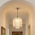 Close-up of a capiz shell pendant chandelier with a metal canopy on a light arched ceiling