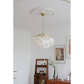 Capiz shell chandelier hanging from a decorative ceiling medallion in a white room.