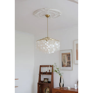 Capiz shell chandelier hanging from a decorative ceiling medallion in a white room.