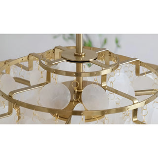 Close-up of the top of a capiz shell chandelier showing gold metal rings and translucent circular shells hanging in layers