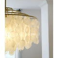 Close-up of the gold frame and hanging rings of a capiz shell chandelier showing the connection points for circular shells.