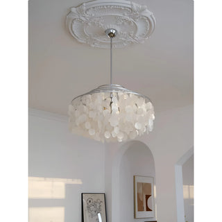 Elegant capiz shell chandelier hanging from ornate white ceiling medallion with modern abstract and floral wall art in a bright living room