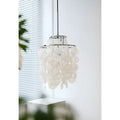 Angled view of a capiz shell chandelier in a modern room with white walls and greenery in the foreground