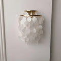 Front view of a gold Capiz Shell Wall Sconce with cascading natural shell discs for modern and coastal interiors