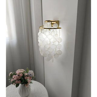 Gold Capiz Shell Wall Sconce installed in a modern living room, providing decorative ambient lighting