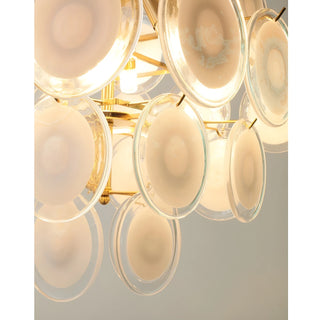 Illuminated close-up of the Cassia chandelier showing copper frame and cream glass