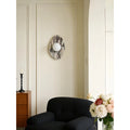 Celestia Marble & Glass Wall Sconce in flower white marble above a black armchair.
