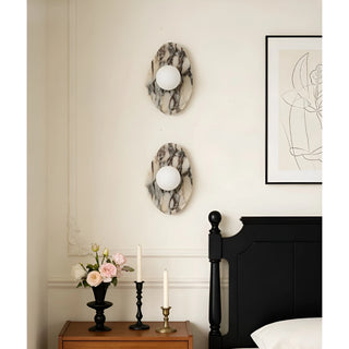Two Celestia Marble & Glass Wall Sconces in long white marble illuminating a modern bedroom.