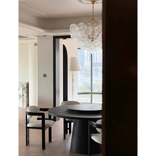 Round ribbed glass chandelier with gold hardware in modern dining space.