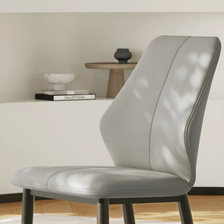 Detail shot of the curved backrest and stitching of the light gray accent chair