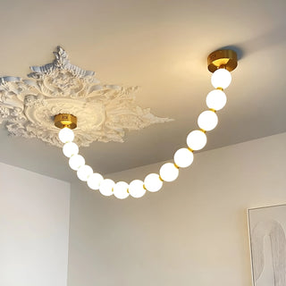 Close-up of luxury pearl necklace LED chandelier mounted on classic ceiling medallion