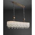 Angled view of turned on clear K9 crystal dining chandelier with gold ceiling mount and adjustable suspension rods
