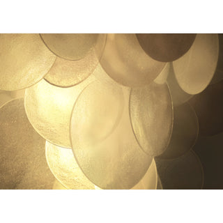 Close-up of textured hand-fritted glass discs, beautifully diffusing the chandelier’s warm ambient glow