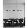 Copper linear chandelier with textured glass shades hanging above a contemporary kitchen island