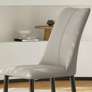 Detailed view of the ergonomic curved backrest with decorative vertical stitching on faux leather