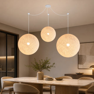 Filara three-ball woven pendant over a marble dining table in a warm modern dining room
