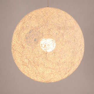 Close-up of a Filara woven cotton ball shade lit softly from within