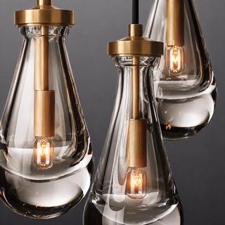 Detail of three Guttara glass raindrops with brass caps and lit E14 bulbs