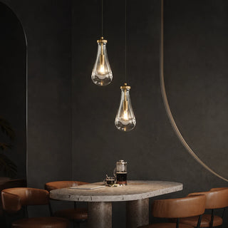 Guttara raindrop pendants above a terrazzo cafe table with leather chairs
