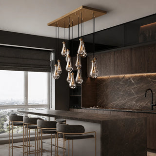 Guttara rectangular raindrop chandelier over a marble kitchen island with a city view