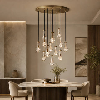 Guttara round 13-light raindrop chandelier above a marble dining table in a warm modern room