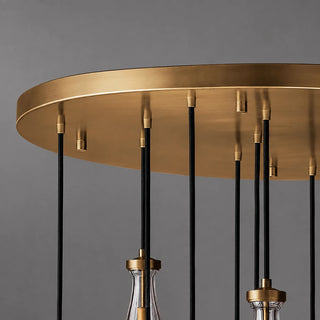 Detail of the round brushed brass canopy and black cords of the Guttara chandelier