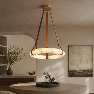 Halara alabaster ring chandelier on leather straps glowing warm over a round dining table