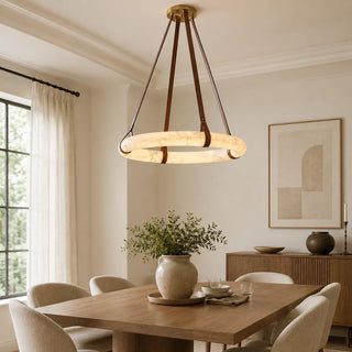 Halara alabaster ring chandelier glowing over a wooden dining table in a bright modern dining room