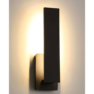 Tall black LED wall sconce glowing against interior or exterior wall