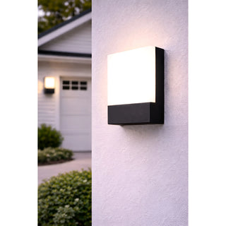 Black-finished LED wall light mounted beside a garage door on a white wall