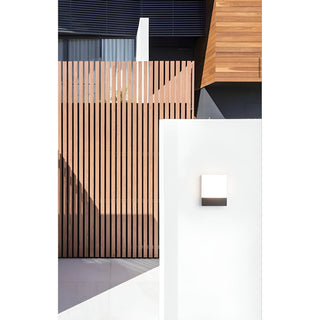 LED wall light installed on a modern white exterior wall near wooden privacy fencing
