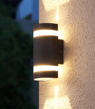 Modern black wall light shining up and down on an exterior concrete wall