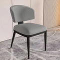 Close-up of gray upholstered dining chair with curved back and black legs