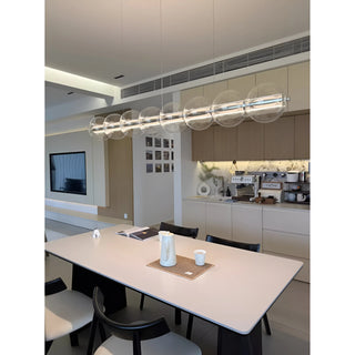 Stylish linear glass chandelier hanging over a contemporary dining table