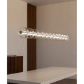 Linear glass pendant light illuminating a minimalist kitchen island